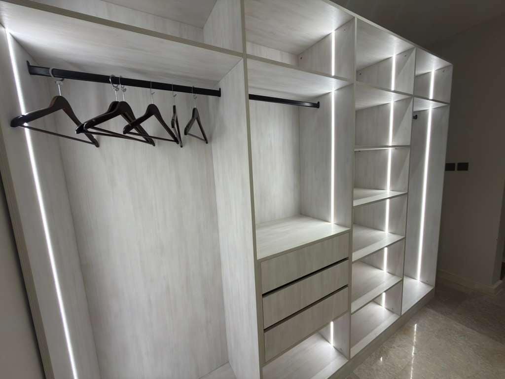 Un vestidor amplio con espacio para colgar ropa y estantes abiertos.