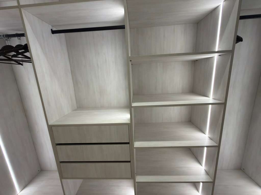 Un vestidor con estantes abiertos y cajones.