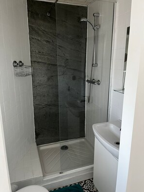 Un baño con ducha, inodoro y lavabo.