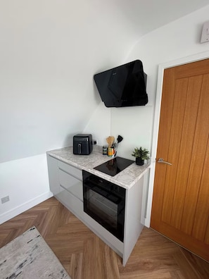 A compact kitchen with a built-in oven, a toaster, and a small countertop. - ‘The Loft’ Near Whitstable, Parking, EV, Courtyard (Yorkletts)