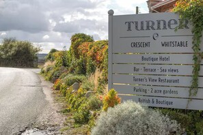 A sign for Turner Crescent Whitstable with amenities including a boutique hotel, bar, terrace, sea views, restaurant, parking, gardens, and a British & Boutique. - ‘The Loft’ Near Whitstable, Parking, EV, Courtyard (Yorkletts)