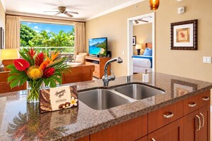 A hotel room with a kitchen area, a dining area with a view, and a bedroom with a balcony. - Honua Kai | Mountain View 1 BR | Free Car w/ 6+ Nights | HKK-230 (Lahaina)