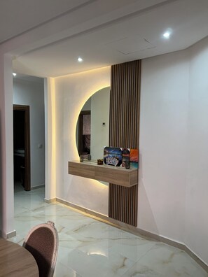 Ein modernes Interieur mit Marmorboden, einer Holzvertäfelung und einer Ablage mit Dekorationen.