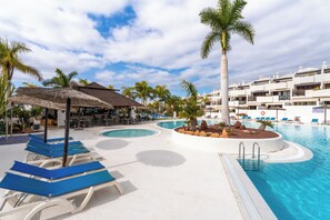 A resort pool area with lounge chairs, a bar, and a building with balconies. - Brand-new duplex with sea views. (CN)