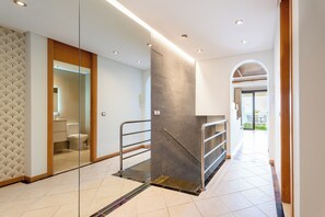 A modern hotel corridor with a glass partition, a staircase, and a view of the outdoor area. - Brand-new duplex with sea views. (CN)
