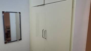 Una habitación con un armario grande, un espejo y un suelo a cuadros.