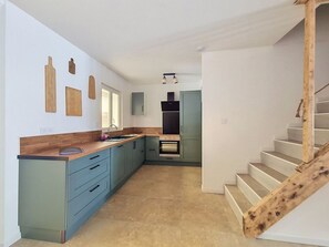 A modern kitchen with a wooden countertop, blue cabinets, and a built-in oven. - Fully renovated vacation home, an 8-minute walk from the ocean (Vendres)