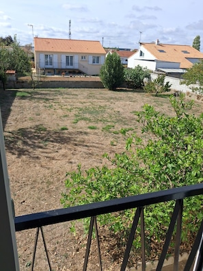 A residential area with houses, a fenced yard, and a balcony with a railing. - Comfortable family home in La Roche-sur-Yon, in a quiet neighborhood (La Roche-sur-Yon)