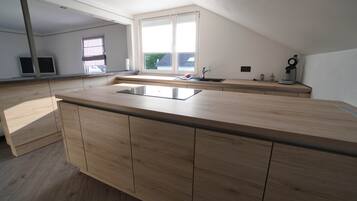 Eine moderne Küche mit einer Holzausziehtheke, einer integrierten Spüle und einem Fenster für natürliches Licht.