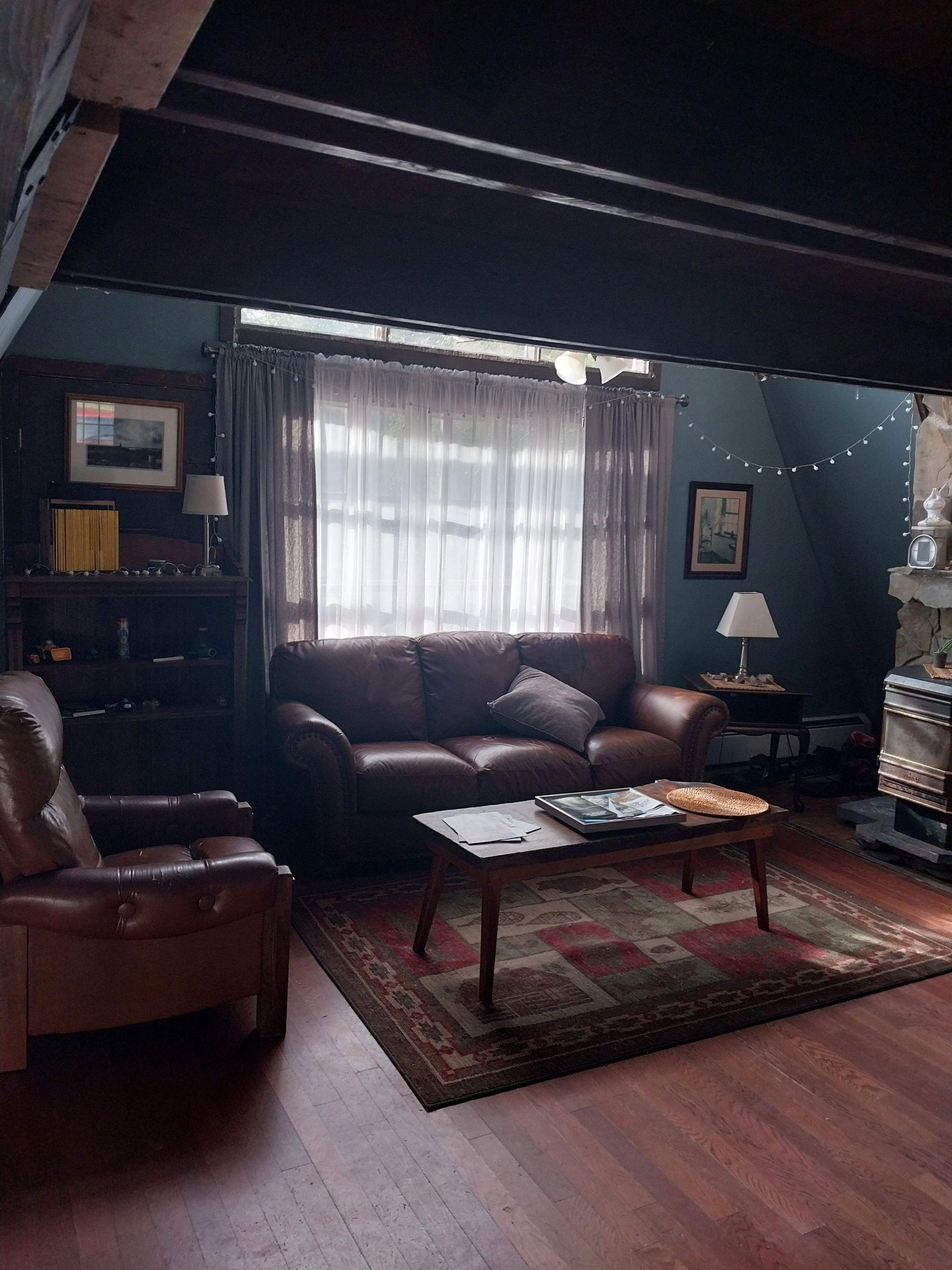 A cozy living room with a leather sofa, a wooden coffee table, and a patterned rug.