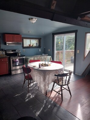 A kitchen with a dining table and chairs, a stove, and cabinets. - Beautiful 3-bedroom house in nice Dover perfect for your getaway (Dover)