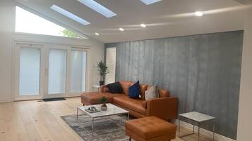A modern living room with a leather sofa, a coffee table, and a small side table.