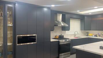 A modern kitchen with dark cabinetry, a built-in oven, and a microwave.