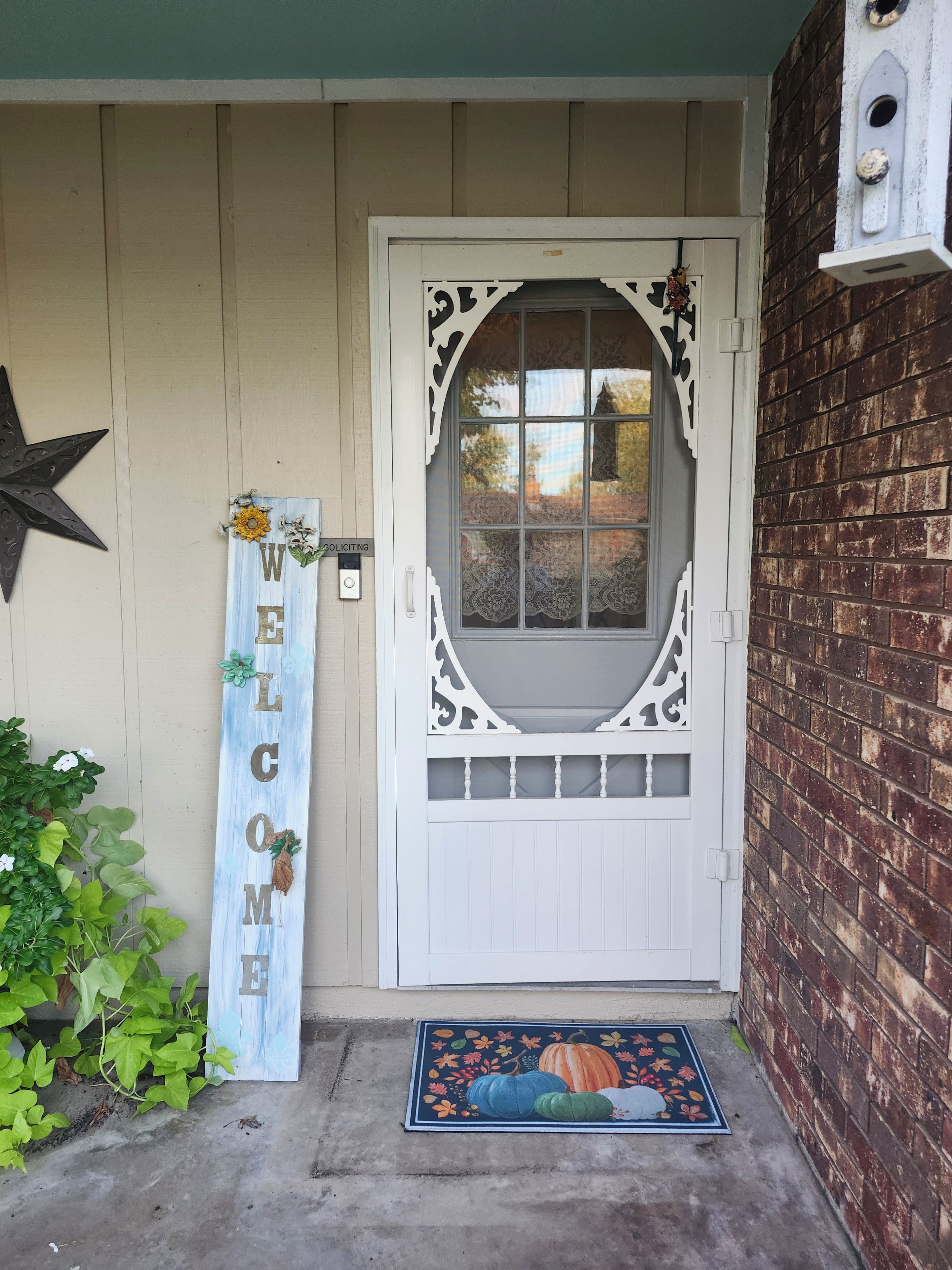 A white door with decorative glass panels, a welcome sign, and a star decoration.