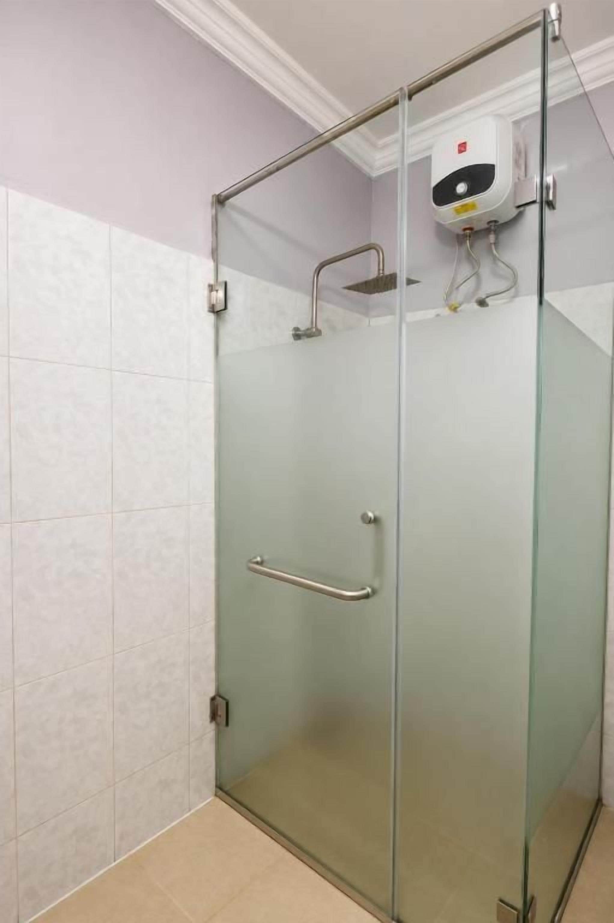 Cabina de ducha con paredes de vidrio, barra de apoyo y panel de control en la pared.