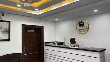 A reception area with a desk, a framed picture on the wall, and a chandelier.