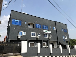A multi-story building with a flat roof, several windows, and air conditioning units. - Caligeo Suites II (Ibadan)