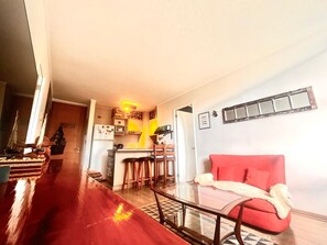A compact living space with a kitchen, dining area, and a red sofa. - COZY, WARM, FLEXIBLE, CENTRAL, 2 bedrooms, 2 bathrooms, 3 living areas + parking (Puerto Varas)