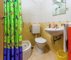 Een badkamer met toilet, wastafel en douche.