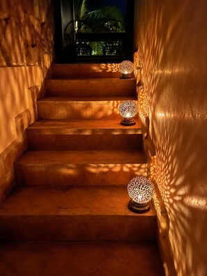 A staircase with warm lighting and decorative lamps.