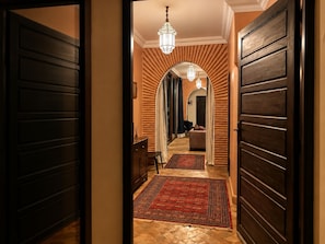 A hallway with wooden paneling, a chandelier, and a seating area with a sofa and chairs. - Villa Malika Private Luxury Villa Marrakech (Marrakech)