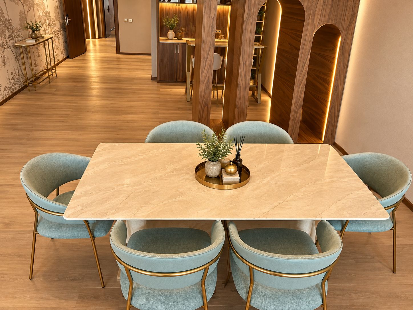 Un comedor con una mesa de mármol, cuatro sillas tapizadas en azul claro con patas doradas y una bandeja decorativa en el centro.