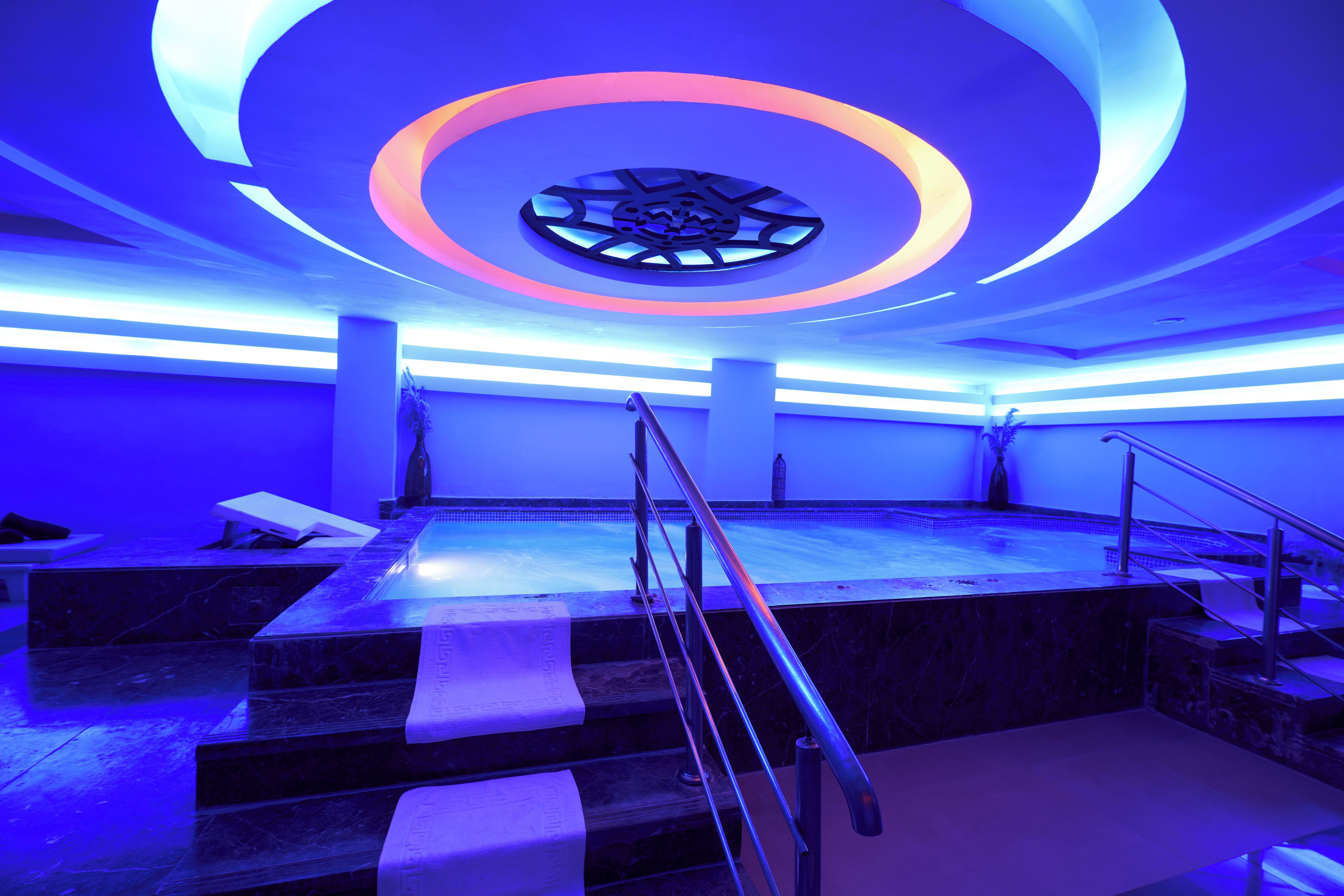 Un intérieur moderne avec une scène centrale, une lucarne circulaire et un espace piscine.