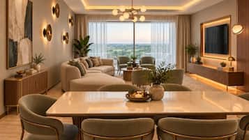 Una sala de estar moderna con un sofá, una mesa de comedor con sillas, un ventanal con vistas y apliques decorativos en la pared.