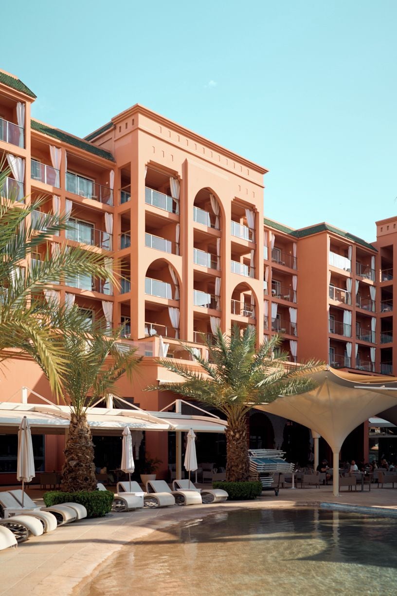 Un hôtel doté de nombreux balcons, d’une piscine et d’espaces de détente en plein air.