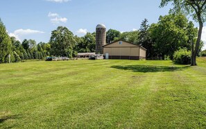 A grassy field with a barn and silo in the background. - Fantastic 4-bedroom house with AC in charming Marcellus (Marcellus)
