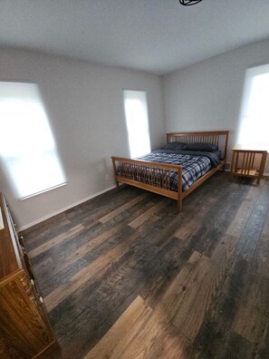 A bedroom with a wooden bed, a small table, and a wardrobe. - Fantastic 4-bedroom house with AC in charming Marcellus (Marcellus)