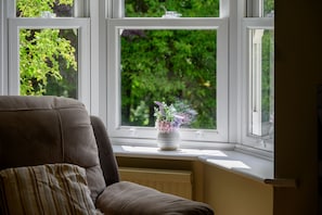 Ein Zimmer mit Fenster, Heizkörper und Stuhl.