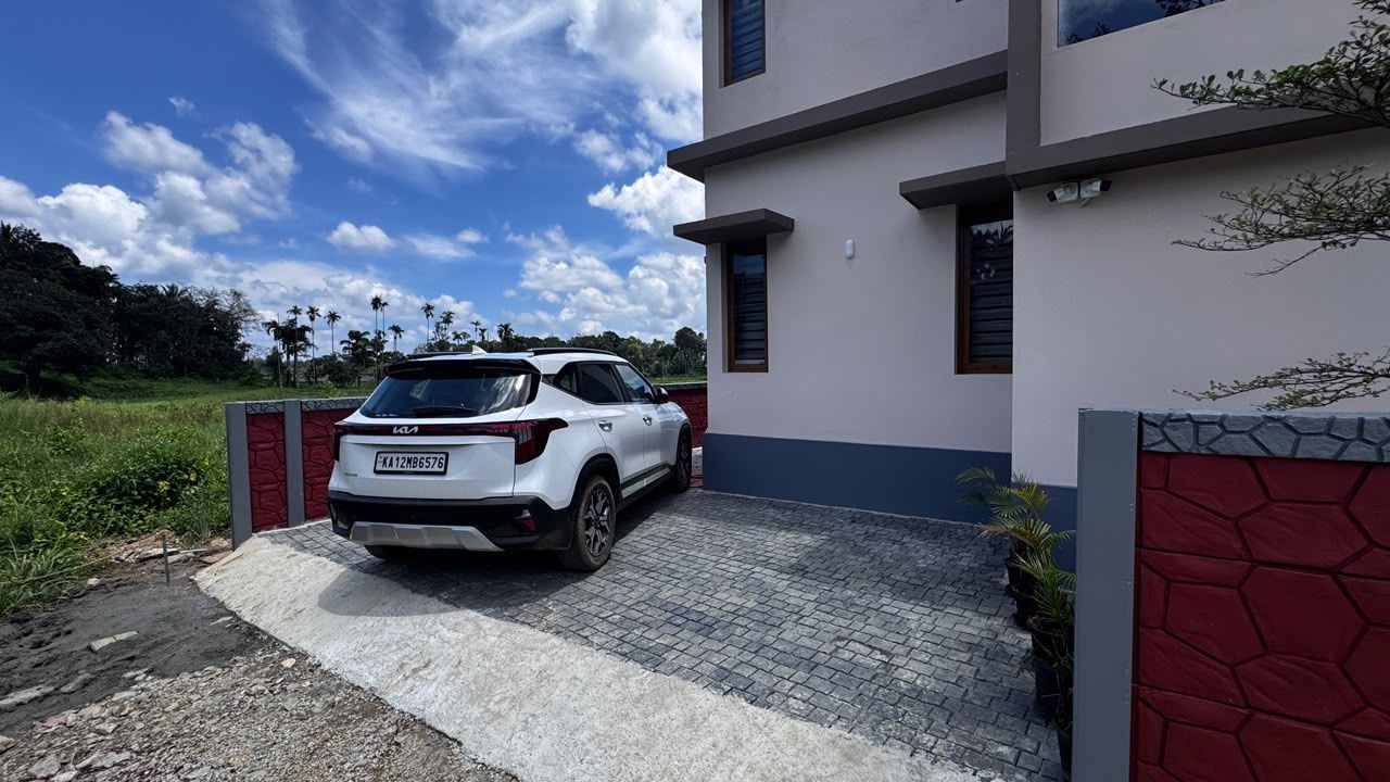 Een witte SUV geparkeerd voor een modern gebouw met een verharde oprit.
