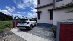 Een witte SUV geparkeerd voor een modern gebouw met een verharde oprit.