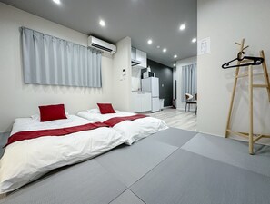 A modern hotel room with a bed, a desk, and a kitchenette. - HANASTAY HIKARI (Osaka)
