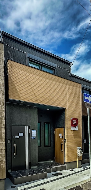 Ein modernes Gebäude mit flachem Dach und einer Holzfassade, mit einem Schild, das ein Restaurant anzeigt.