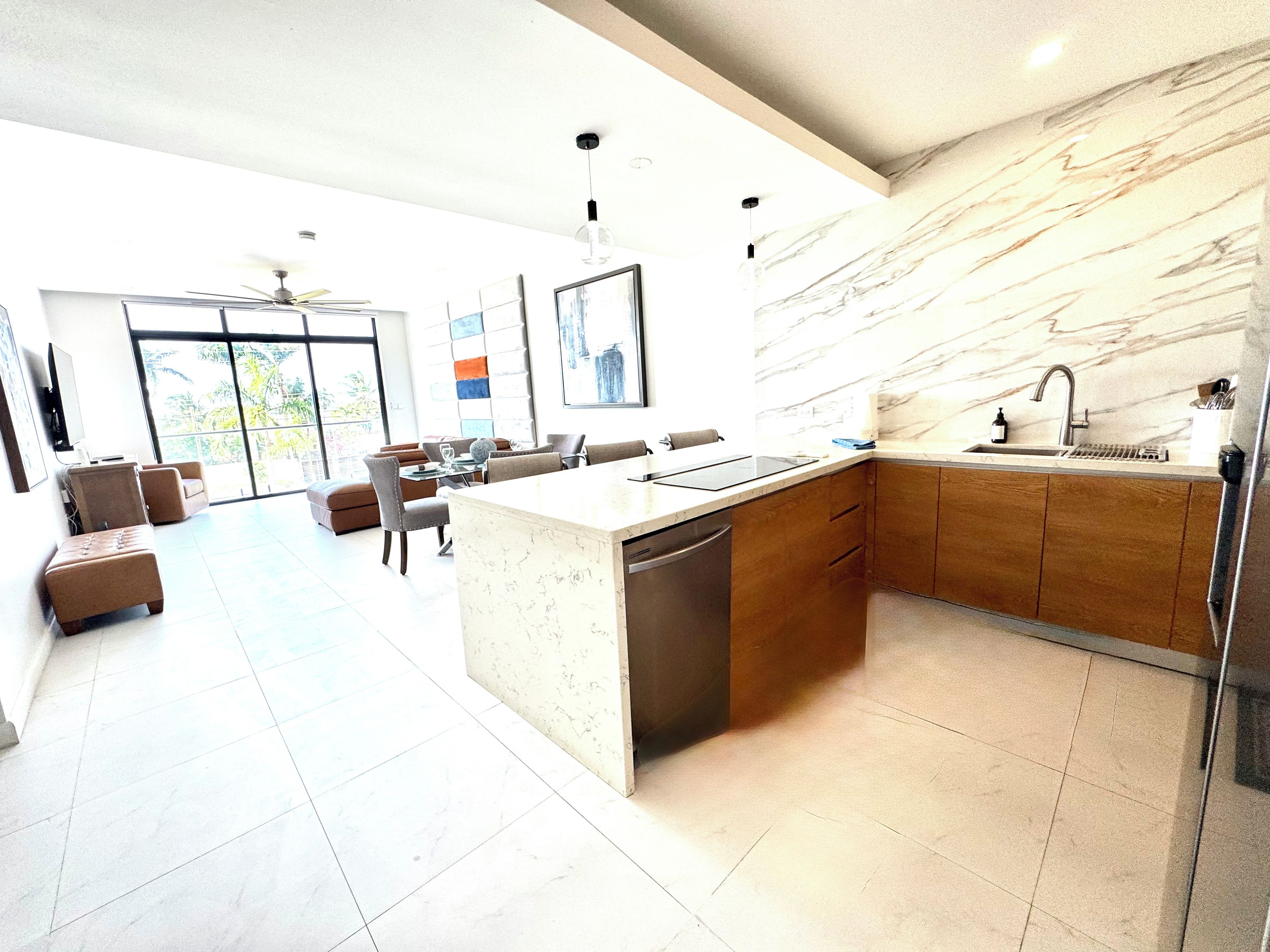 A modern kitchen with a marble backsplash, wooden cabinets, and a central island.