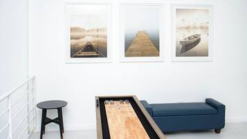 A room with a blue sofa, a wooden coffee table, and three framed pictures on the wall.