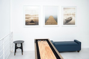Una stanza con un divano blu, un tavolino in legno e tre quadri appesi al muro.