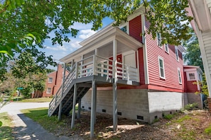 A two-story house with a covered porch and a staircase leading to the upper floor. - Perfect for Groups! 4-Bedroom Home Near the Waterfront + Dining (Washington)