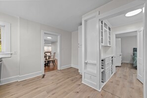 A modern interior with a wooden floor, white walls, and a dining area visible through an open door. - Perfect for Groups! 4-Bedroom Home Near the Waterfront + Dining (Washington)