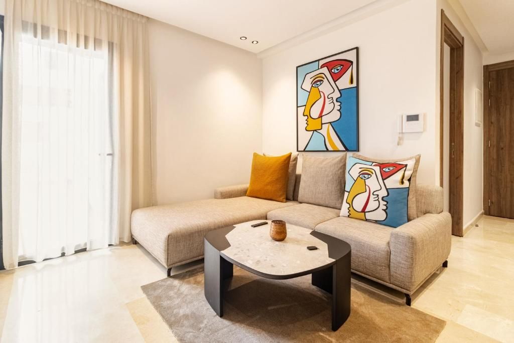 Una sala de estar moderna con un sofá, una mesa de centro y obras de arte en la pared.