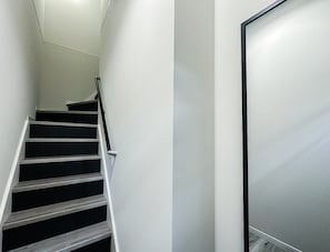 A staircase with a handrail and a wall with a door frame. - HANASTAY MINE (Osaka)