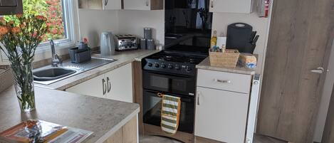 A modern kitchen with a gas stove, oven, and a sink.