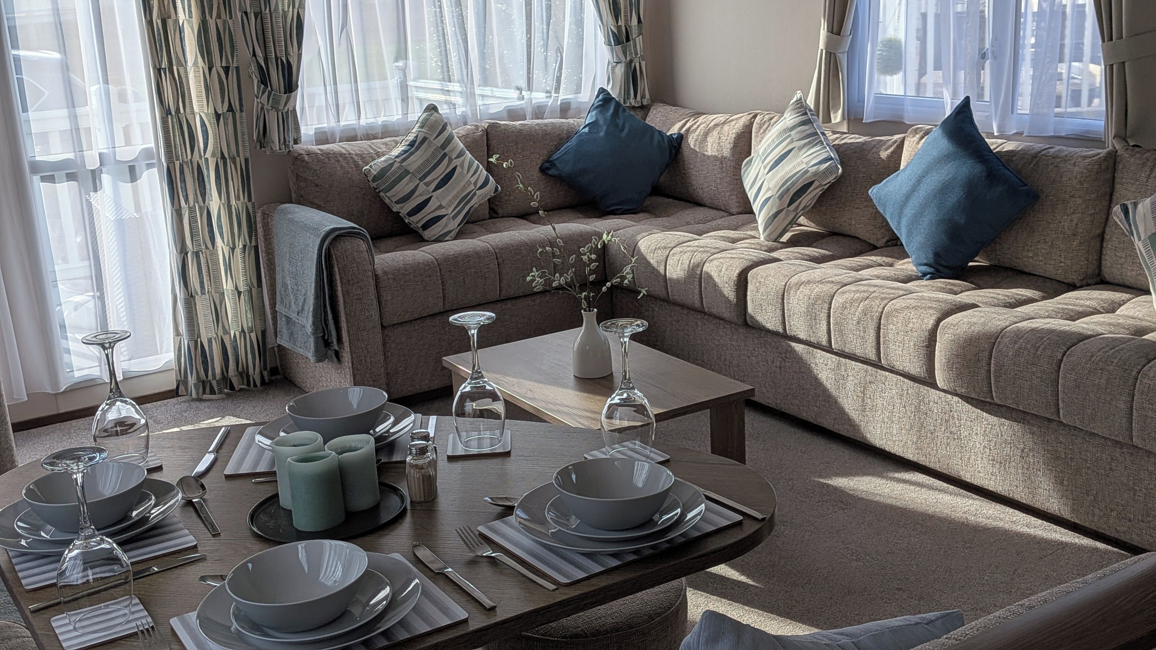 A furnished living room with a sofa set, a coffee table, and a dining table set for a meal.
