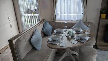 A dining area with a round table set for four, including plates, glasses, and cutlery.