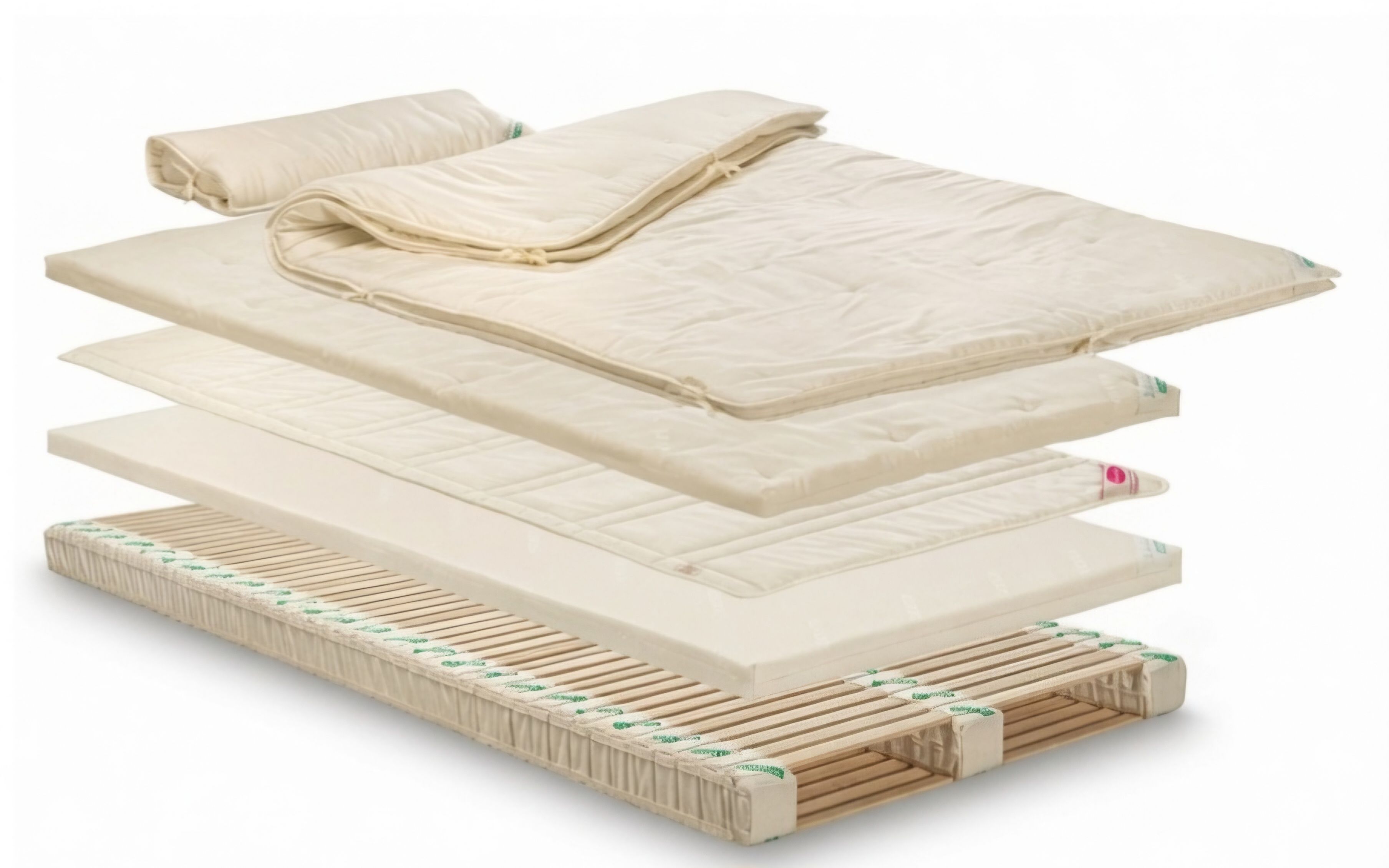 A stack of mattresses with a wooden frame and a folded blanket on top.