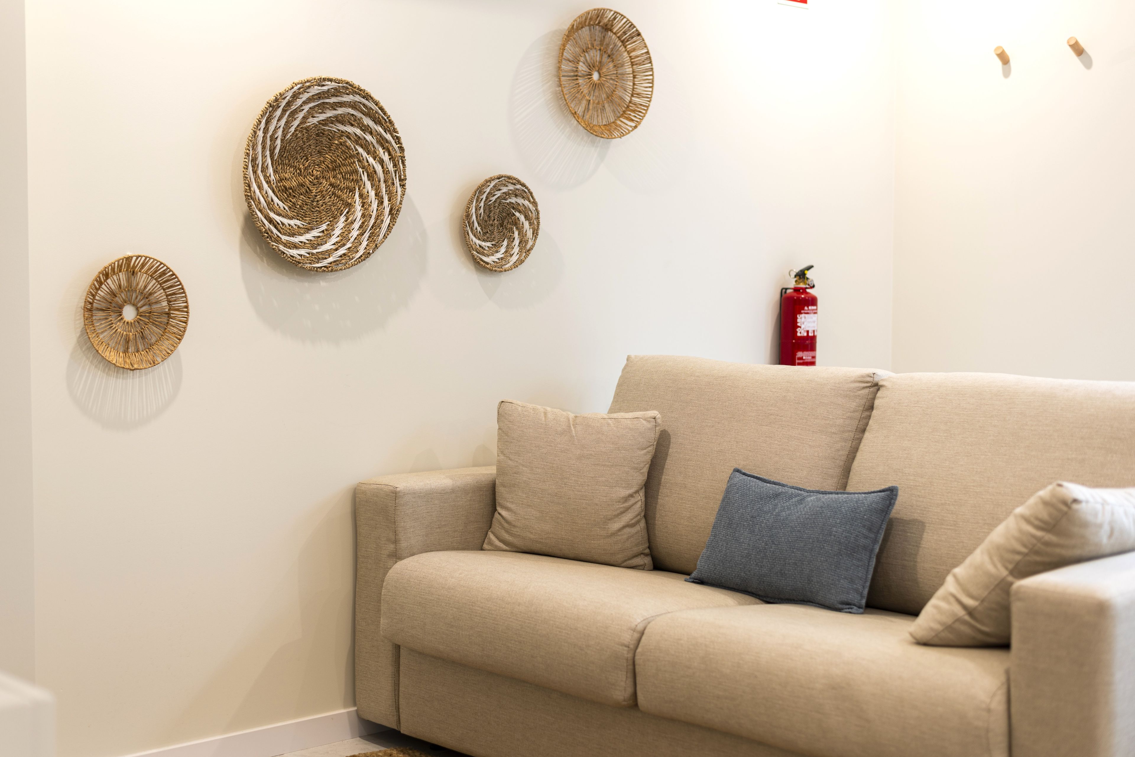 Cozy neutral sofa nook with boho rattan accents—calm, inviting retreat.