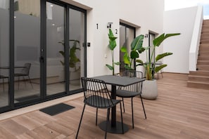 An outdoor patio area with a table and chairs, potted plants, and a staircase. - Villa 41 Faro Airport | Studio 2 | 4 Guests | Early/Late Flights (Faro)