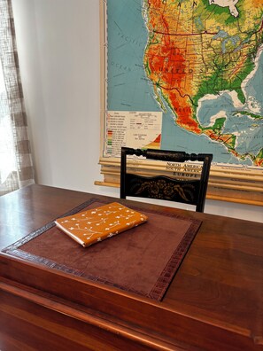 A wooden table with a map of North America, a notebook, and a chair. - Something Blue: New-to-market 2-bedroom peaceful retreat (Nevada)